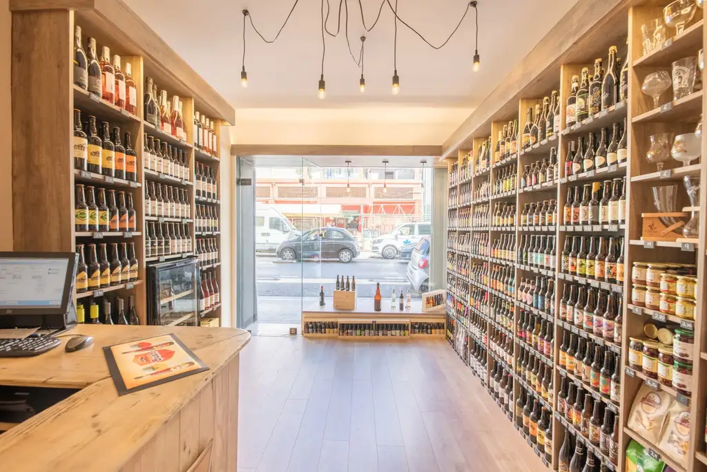 Intérieur de La Cave Libération : rayonnages de bières du sol au plafond